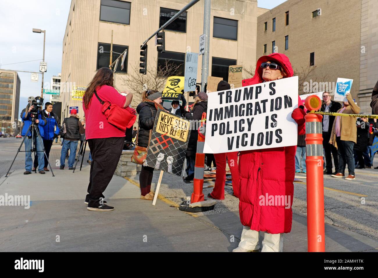 Protestando visita da Trump al centro di Toledo, Ohio, Stati Uniti d'America il 9 gennaio 2020, con un cartello con la dicitura "Trump la politica in materia di immigrazione è spietata" Foto Stock