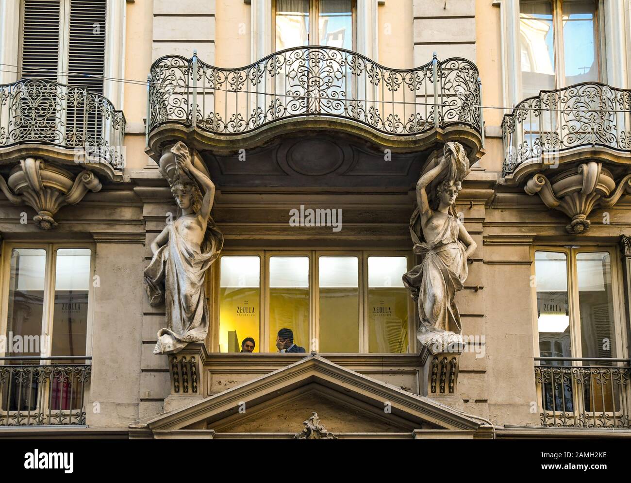 Stile barocco façade di un palazzo decorato con un paio di cariatidi che sostengono un balcone in Via Garibaldi nel centro di Torino, Piemonte, Italia Foto Stock