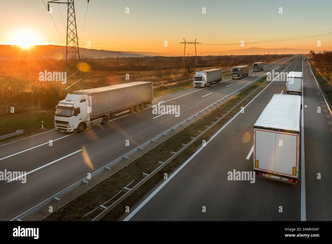 Convogli di camion di trasporto che passano l'un l'altro su un'autostrada. Trasporto in autostrada con percorsi per camion Foto Stock