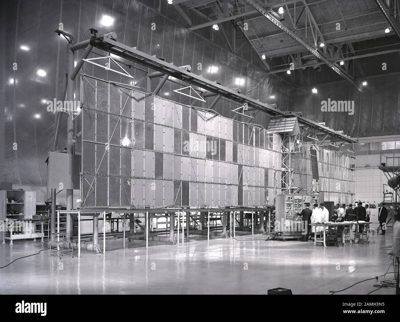 I tecnici ispezionano l'apertura alare di 96 piedi del satellite Pegasus prima del lancio alla struttura di Fairchild-Hiller a Hagerstown, Maryland, Stati Uniti, 16 febbraio 1965. Immagine gentilmente concessa dalla NASA. () Foto Stock
