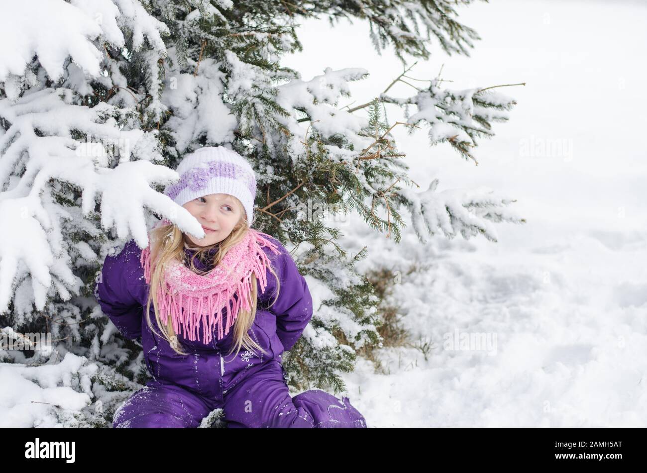 primo piano ritratto di bella bambina sotto l'albero coperto di neve in magia wintertime natura Foto Stock