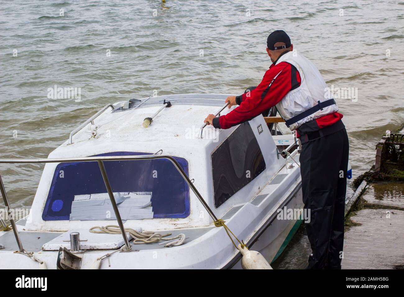 9 giugno 2017 un armatore che porta la sua piccola barca in fibra di vetro verso la riva di Warsash, Hampshire, in un rimorchio in attesa per portarla fuori Foto Stock