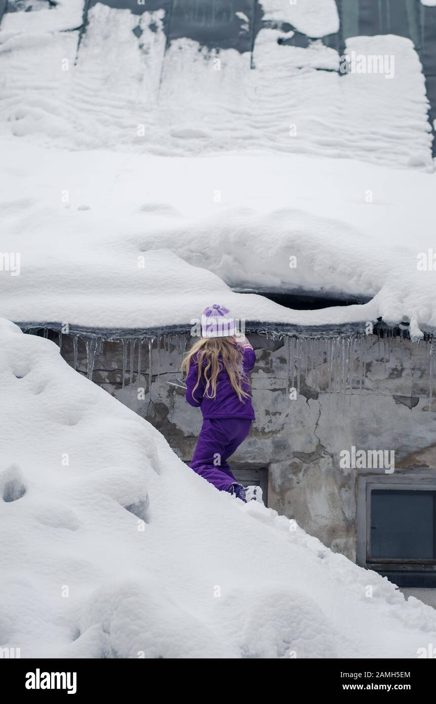 adorabile ragazza con capelli lunghi divertirsi con ghiaccioli congelati in neve meraviglia Foto Stock
