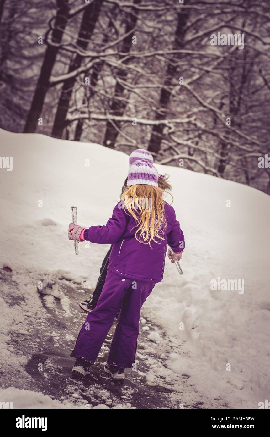 adorabile ragazza che si diverte con ghiaccioli congelati in neve meraviglia Foto Stock