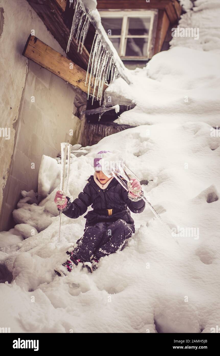 adorabile ragazza che si diverte con ghiaccioli congelati in neve meraviglia Foto Stock