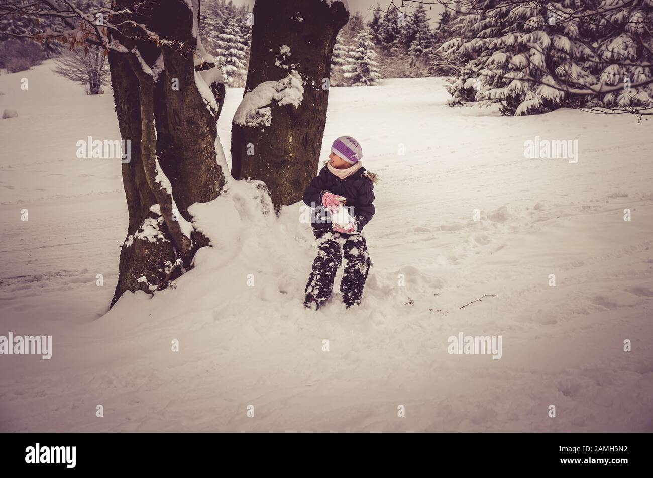 adorabile ragazza divertirsi con lo snowman in neve meraviglia Foto Stock