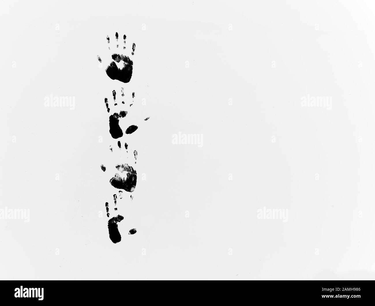 Stampe a mano nere su una parete bianca Foto Stock