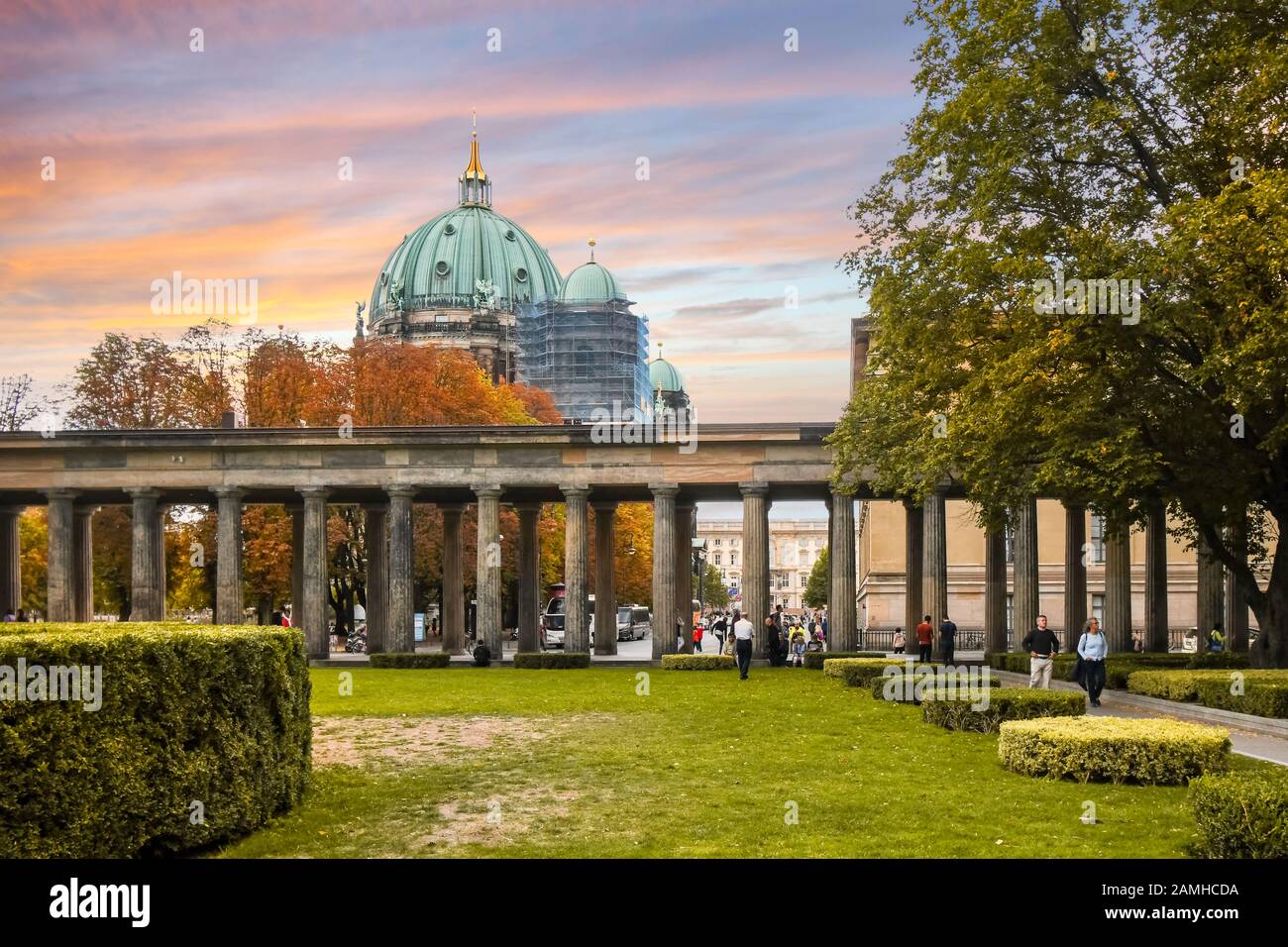 I turisti e i tedeschi locali godono di una giornata autunnale sotto un cielo colorato sull'Isola dei Musei con la Cattedrale di Berlino in vista mentre le foglie diventano arancioni. Foto Stock