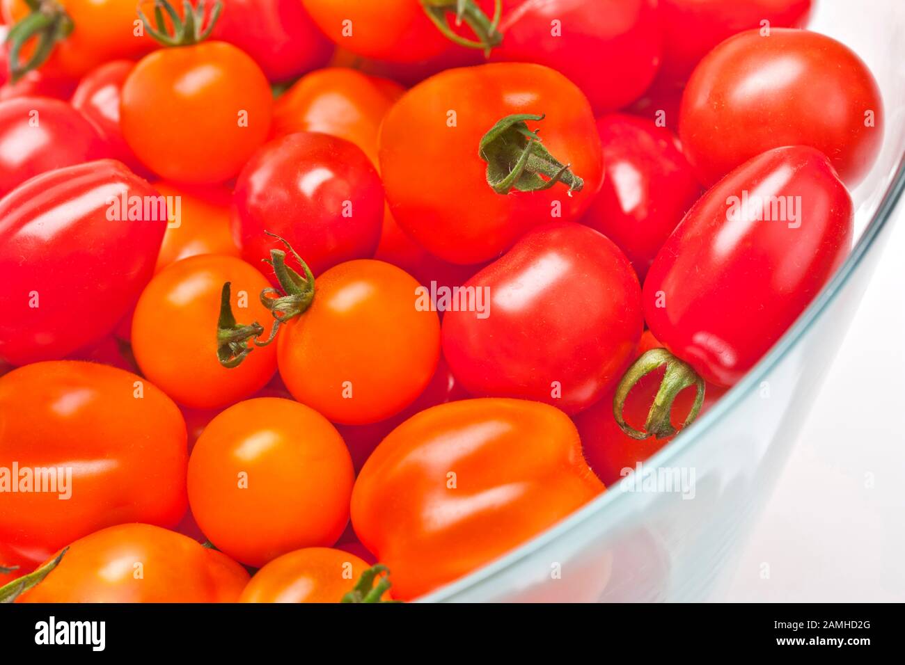 Pomodori rossi e arancioni freschi in una ciotola Foto Stock
