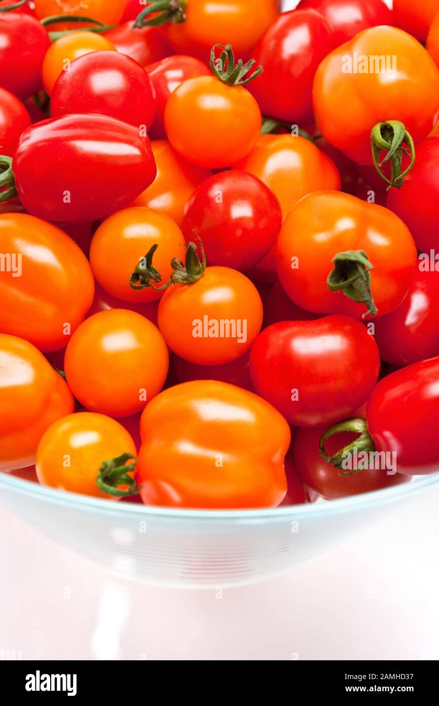 Pomodori rossi e arancioni freschi in una ciotola Foto Stock