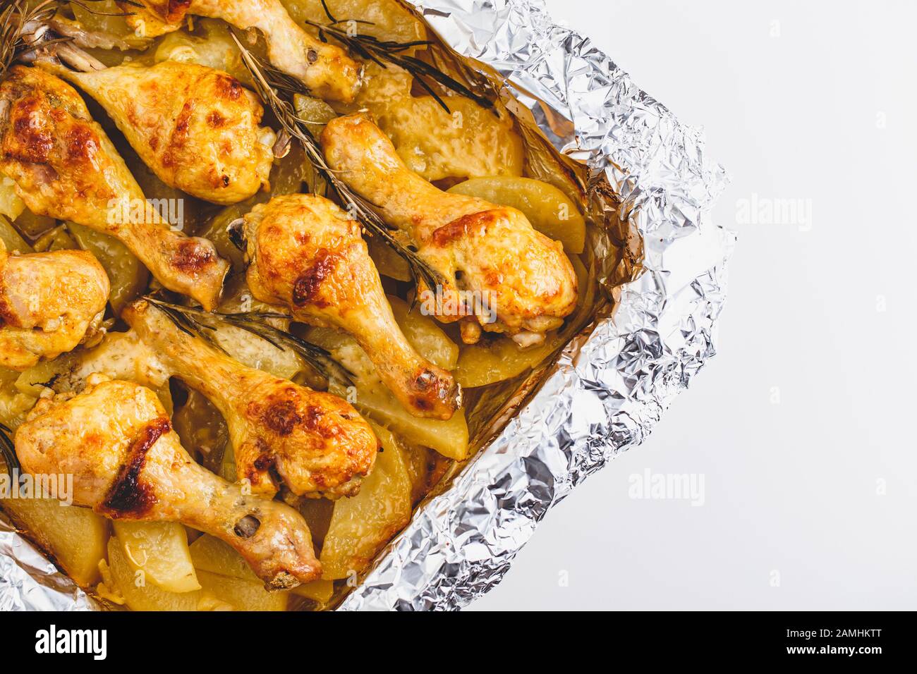 Gambe di pollo appetitose Cotte con Patate e rosmarino In Lamina. Primo piano. Foto Stock