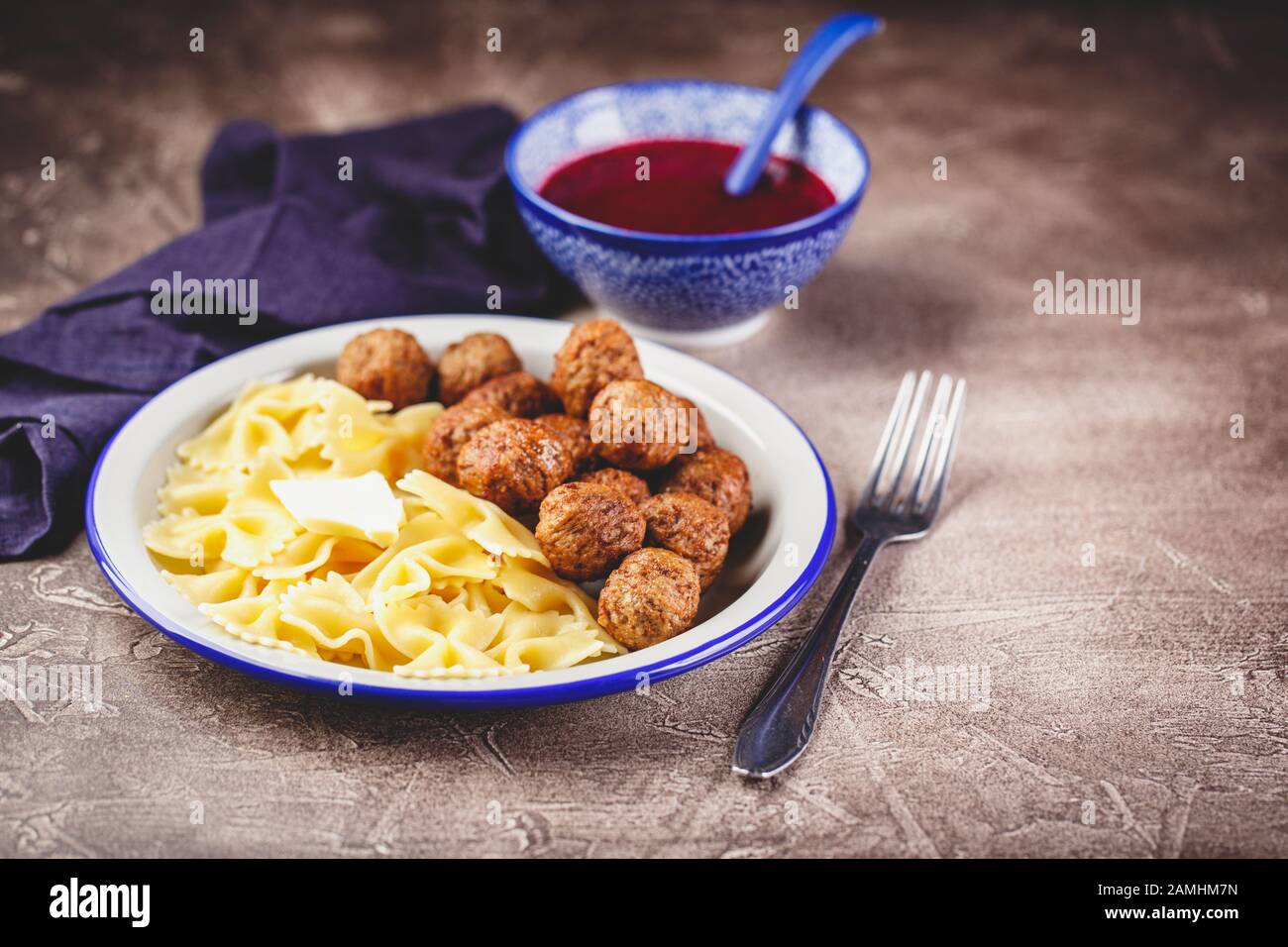 Pasta Farfalle con polpette e salsa di mirtilli con spezie ed erbe rosmarino, cannella e anice. Polpette in umido in salsa di bacche dolci. Posizionare per Foto Stock