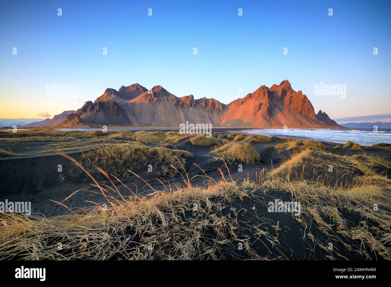 Catena montuosa di Vestrahorn situata a Stokksnes, il Capo meridionale dell'Islanda. Picchi che raggiungono l'alto 454m circondato da dune di sabbia vulcanica nera. Foto Stock