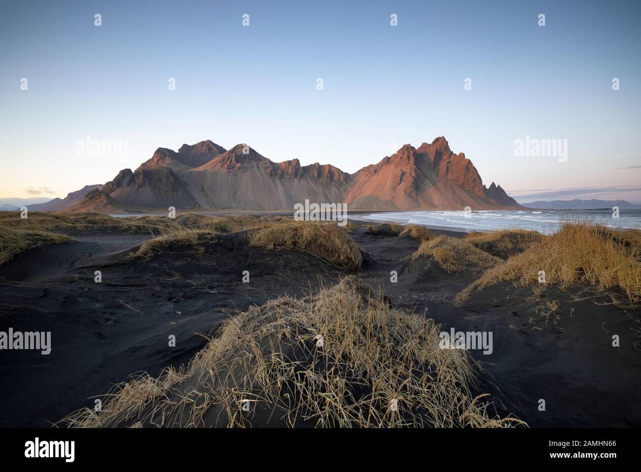 Catena montuosa di Vestrahorn situata a Stokksnes, il Capo meridionale dell'Islanda. Picchi che raggiungono l'alto 454m circondato da dune di sabbia vulcanica nera. Foto Stock