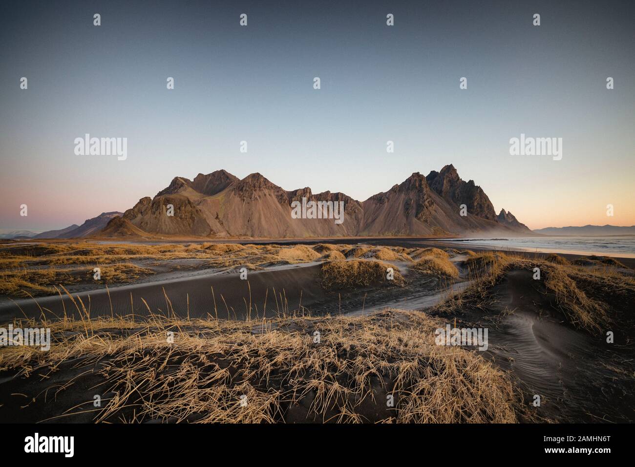 Catena montuosa di Vestrahorn situata a Stokksnes, il Capo meridionale dell'Islanda. Picchi che raggiungono l'alto 454m circondato da dune di sabbia vulcanica nera. Foto Stock