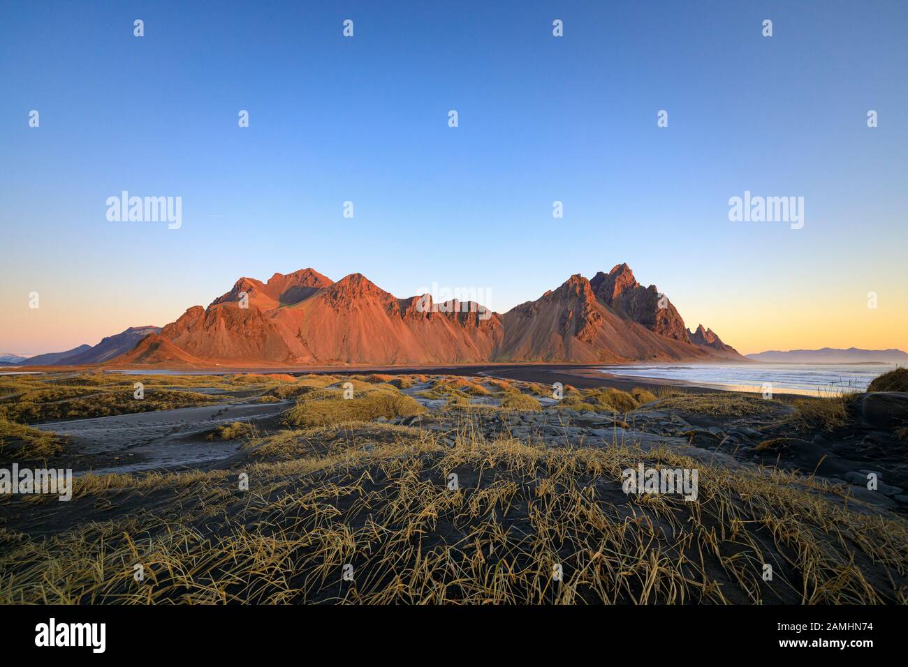 Catena montuosa di Vestrahorn situata a Stokksnes, il Capo meridionale dell'Islanda. Picchi che raggiungono l'alto 454m circondato da dune di sabbia vulcanica nera. Foto Stock