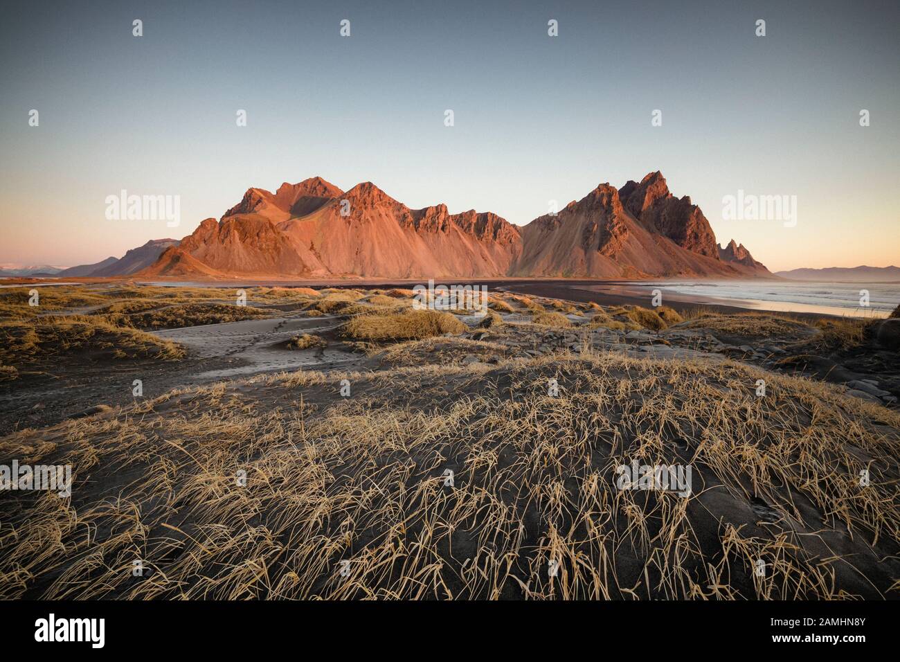 Catena montuosa di Vestrahorn situata a Stokksnes, il Capo meridionale dell'Islanda. Picchi che raggiungono l'alto 454m circondato da dune di sabbia vulcanica nera. Foto Stock