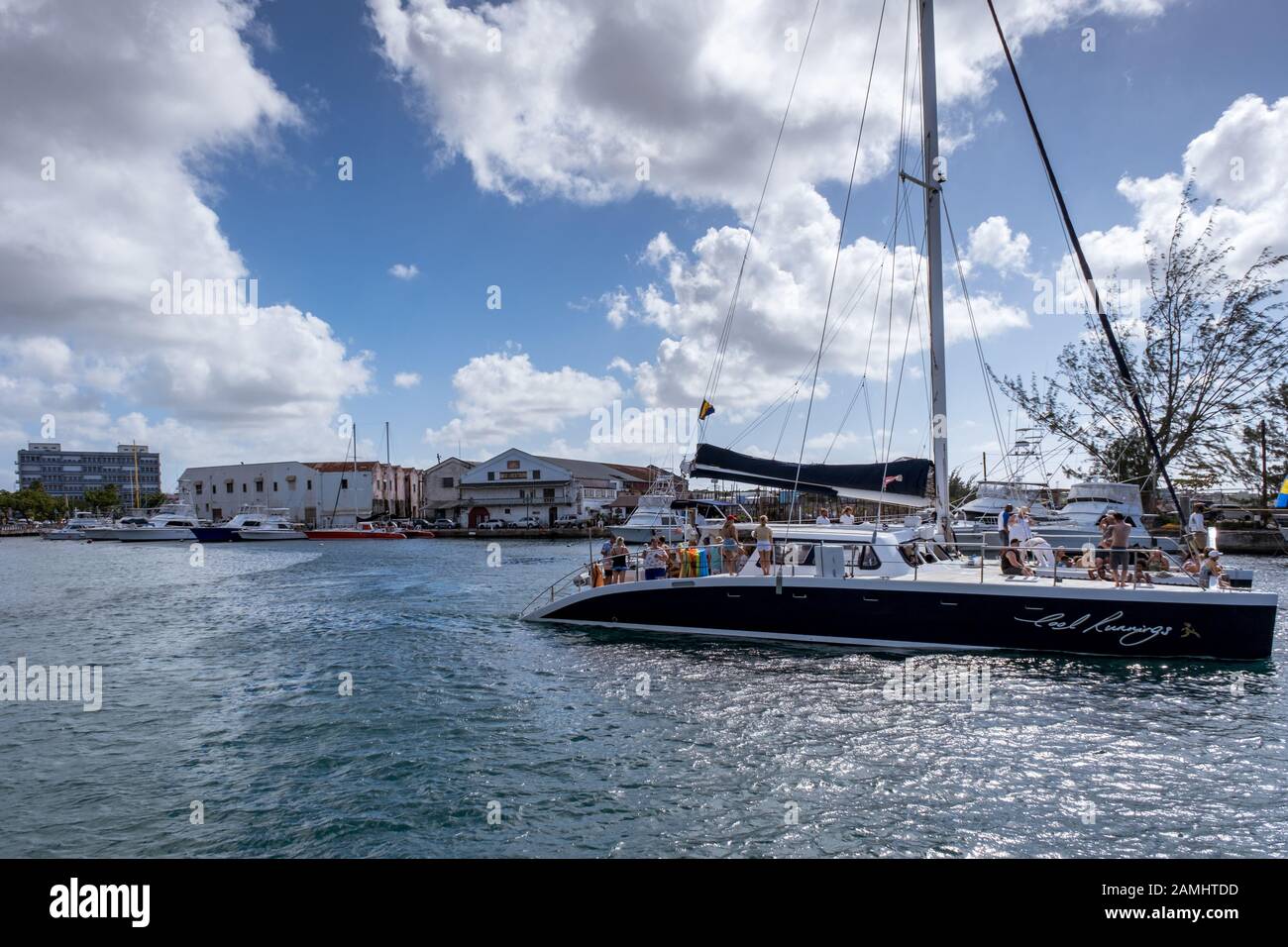 Un catamarano con i turisti in gita vele al porto di Bridgetown, Barbados, West Indies, dei Caraibi Foto Stock
