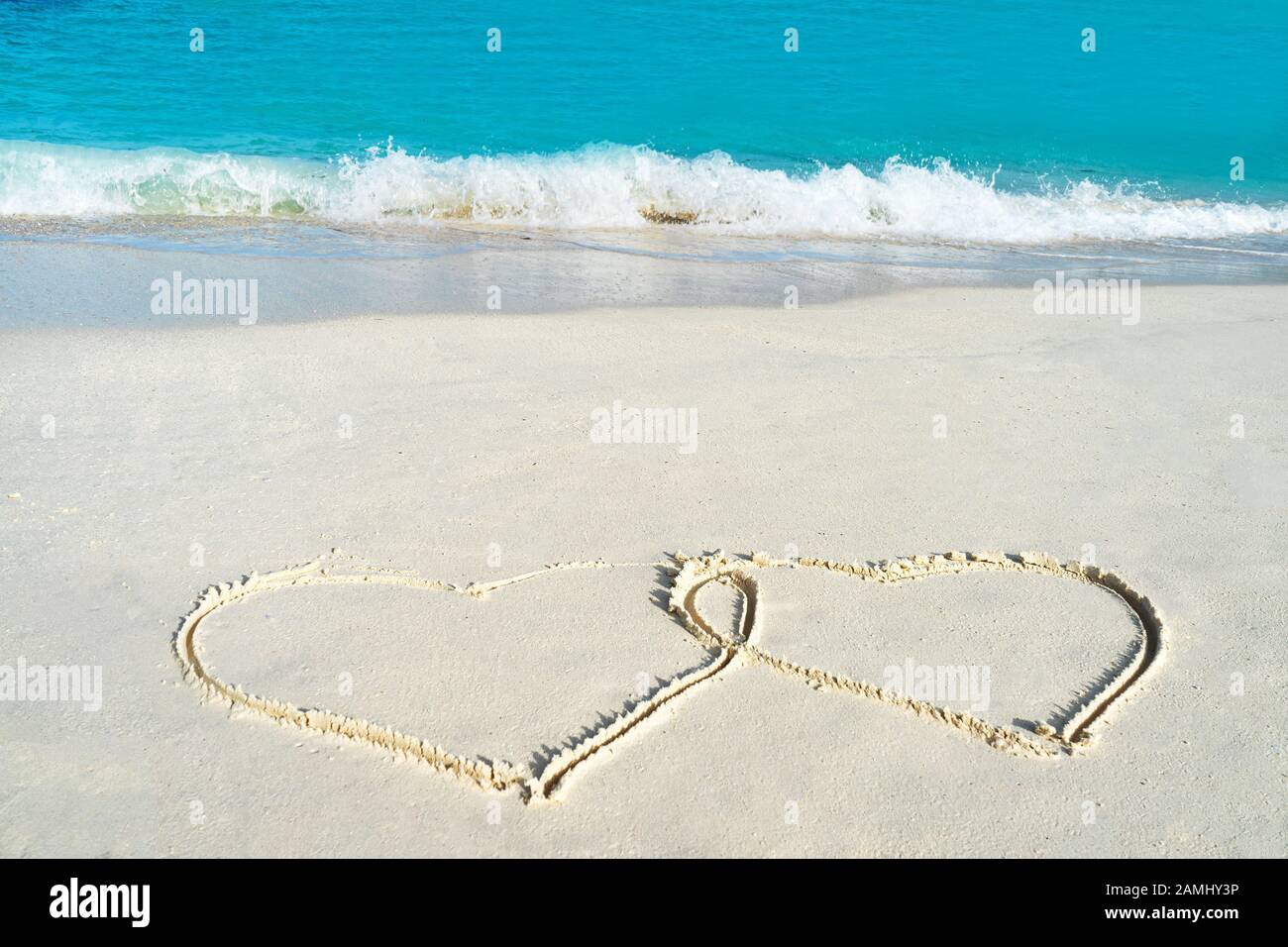 Forma del cuore sulla spiaggia di sabbia bianca gialla. Concetto di amore per San Valentino o vacanza estiva. Foto Stock