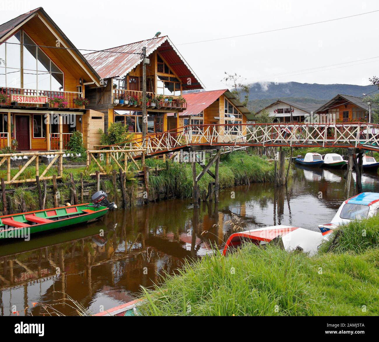 Barche di legno colorate e edifici A cornice su un canale nel villaggio di Encano, Laguna la Cocha, Colombia Foto Stock