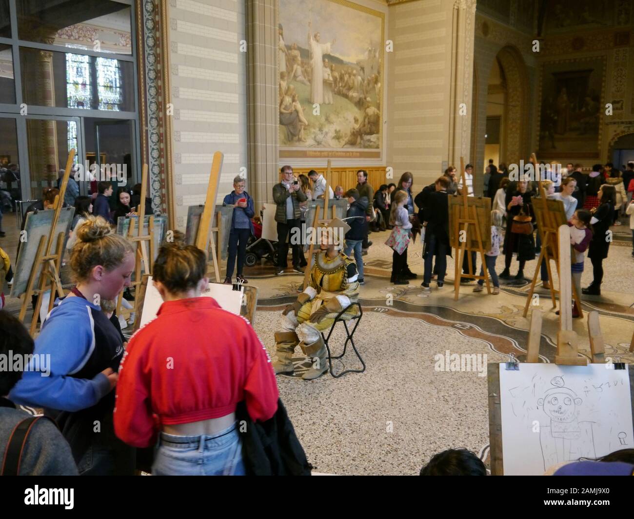 I turisti nel Rijksmuseum, Amsterdam, Olanda, guardano la gente che disegna un modello vestito con abiti seicenteschi. Foto Stock