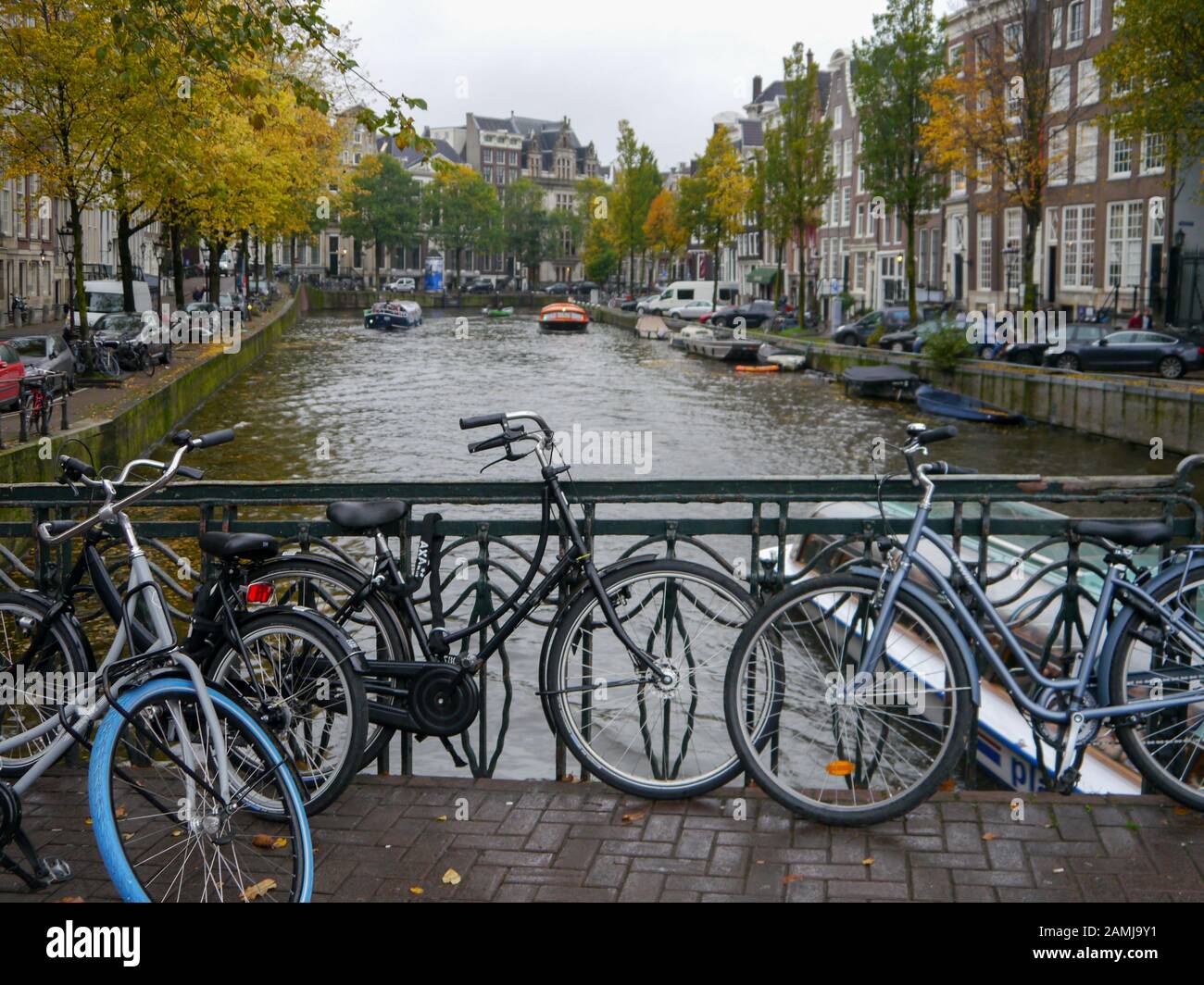 Un ponte su un canale nella città di Amsterdam con biciclette incatenato alla ringhiera. Foto Stock