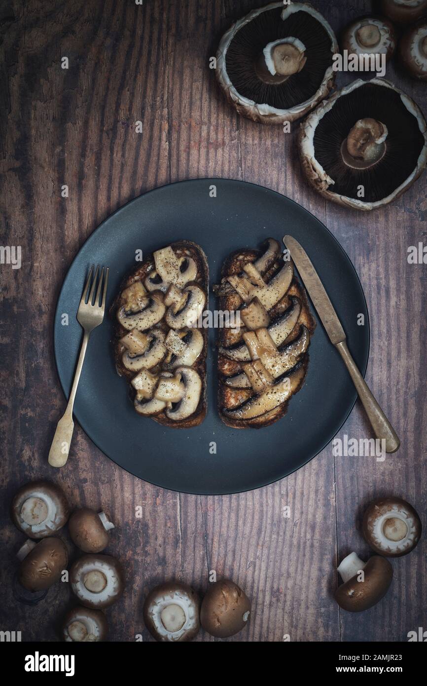 Funghi su pane tostato. Utilizzando un pane con pasta di pane con portobello e funghi di castagno Foto Stock