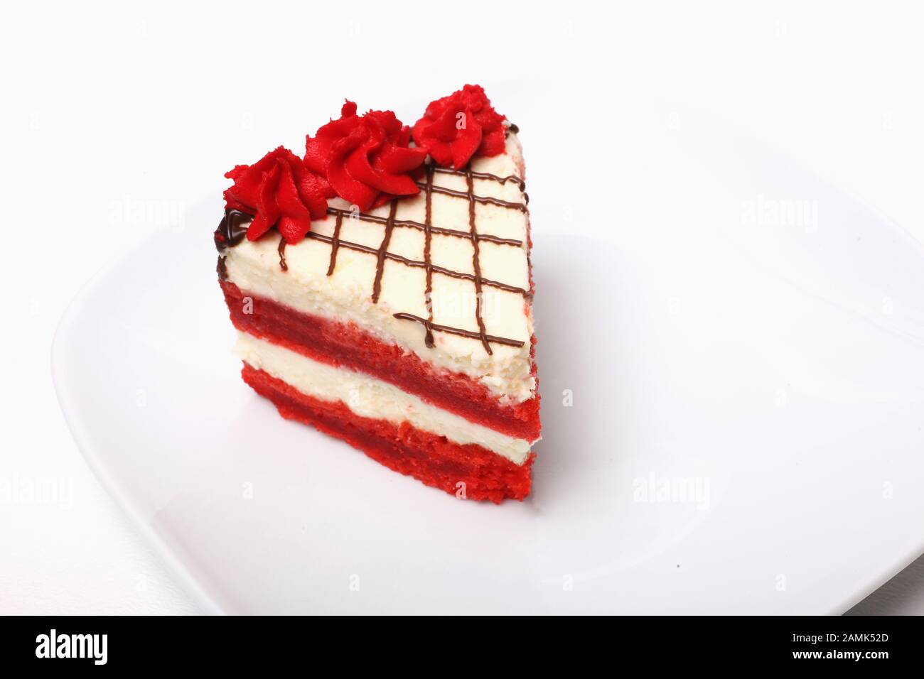 Un pezzo di torta di ciliegia su un piatto su uno sfondo bianco Foto Stock