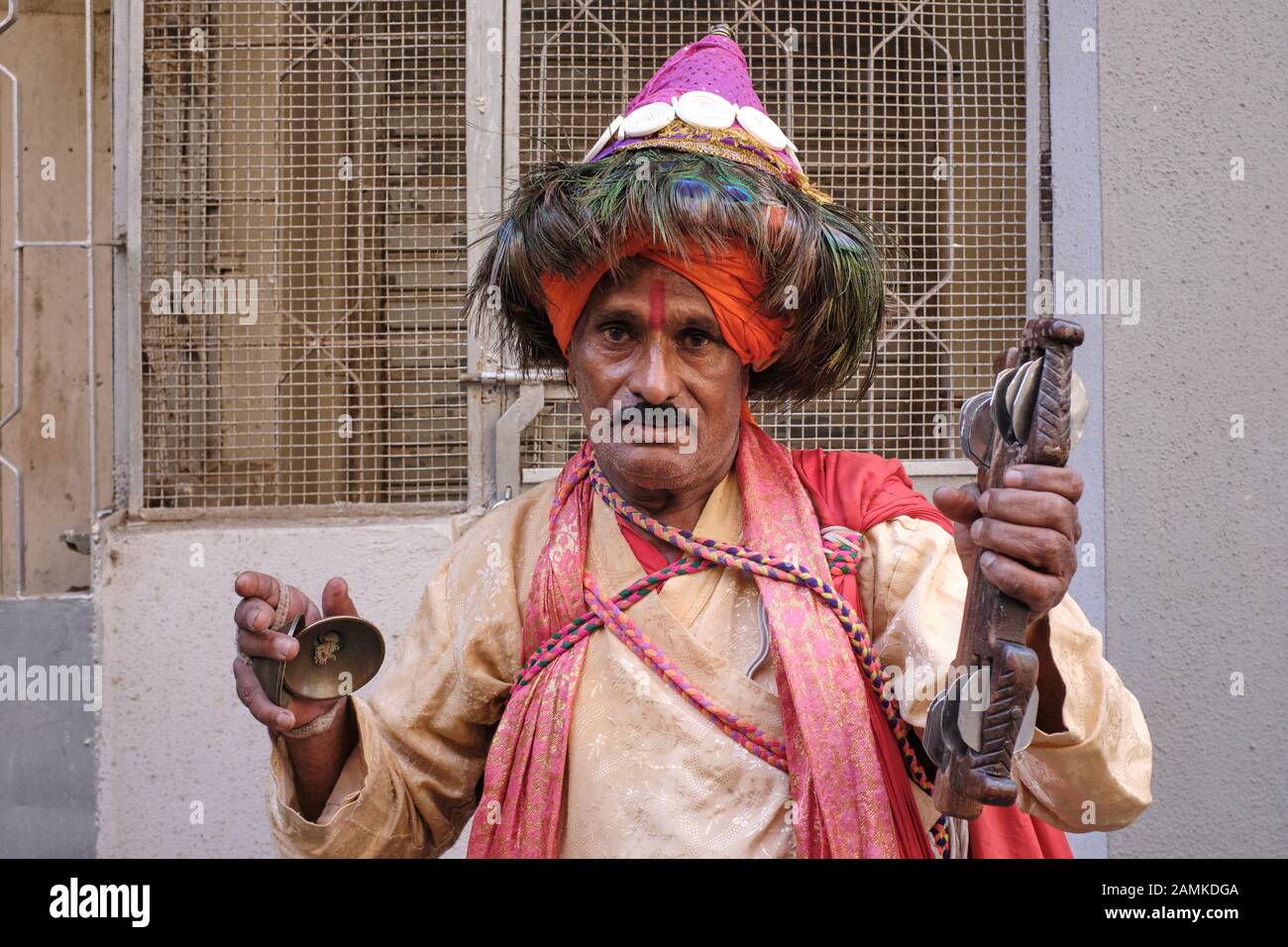 Un Vasudev, un adoratore del dio indù Krishna nello stato indiano del Maharashtra, cantando canzoni in lode di Krishna e raccogliendo elemosine; Mumbai, India Foto Stock