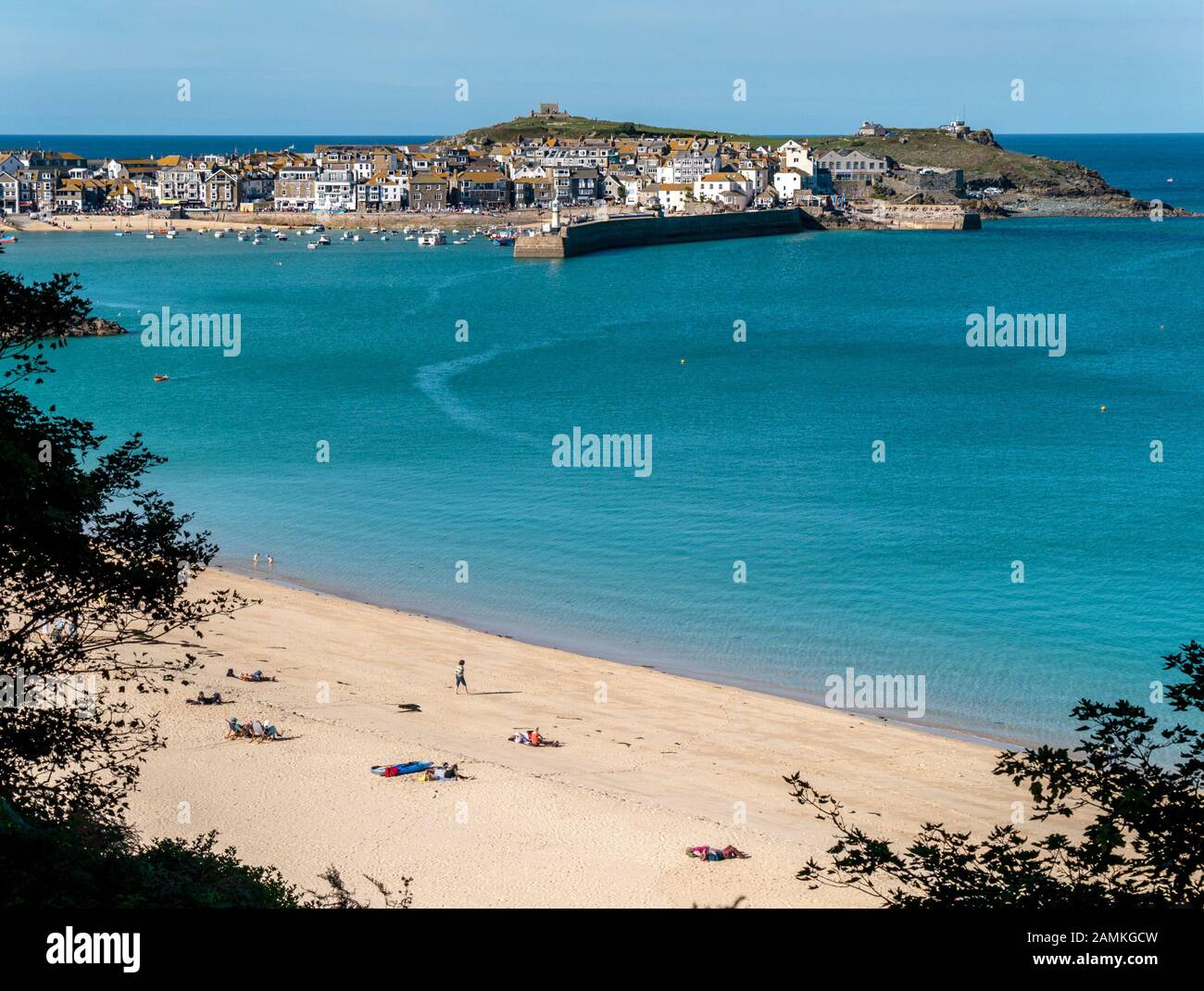 Sabbiosa spiaggia di Porthminster con il Cornish cittadina balneare e di villeggiatura di St. Ives al di là su soleggiate giornate estive, Cornwall, Regno Unito Foto Stock