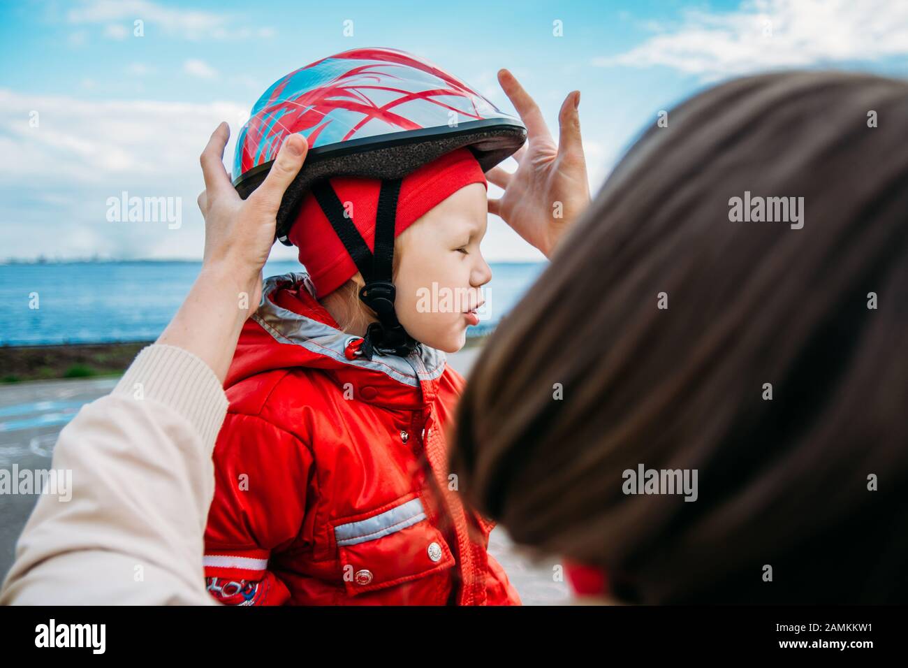 donna indossa un casco il tuo bambino per il pattinaggio Foto Stock