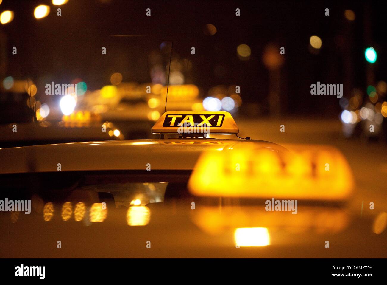 I taxi con cartelli illuminati aspettano i clienti alla Maximiliansplatz di Monaco. [traduzione automatizzata] Foto Stock