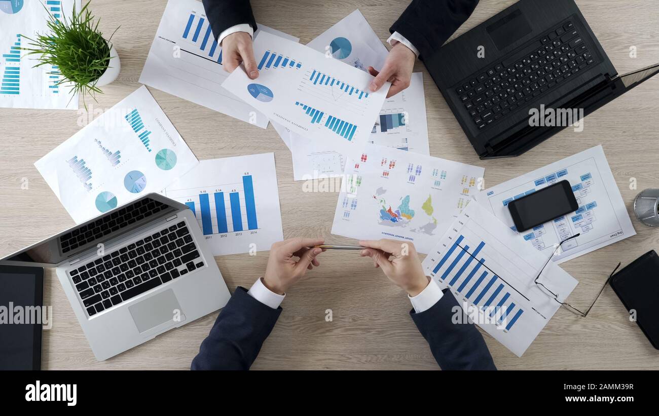 I manager controllano i diagrammi di business, discutono il rapporto finanziario, il brainstorming Foto Stock
