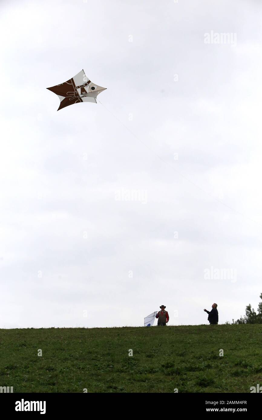 Due uomini stanno cercando di volare i loro aquiloni nel Parco Riemer con poco vento. [traduzione automatizzata] Foto Stock