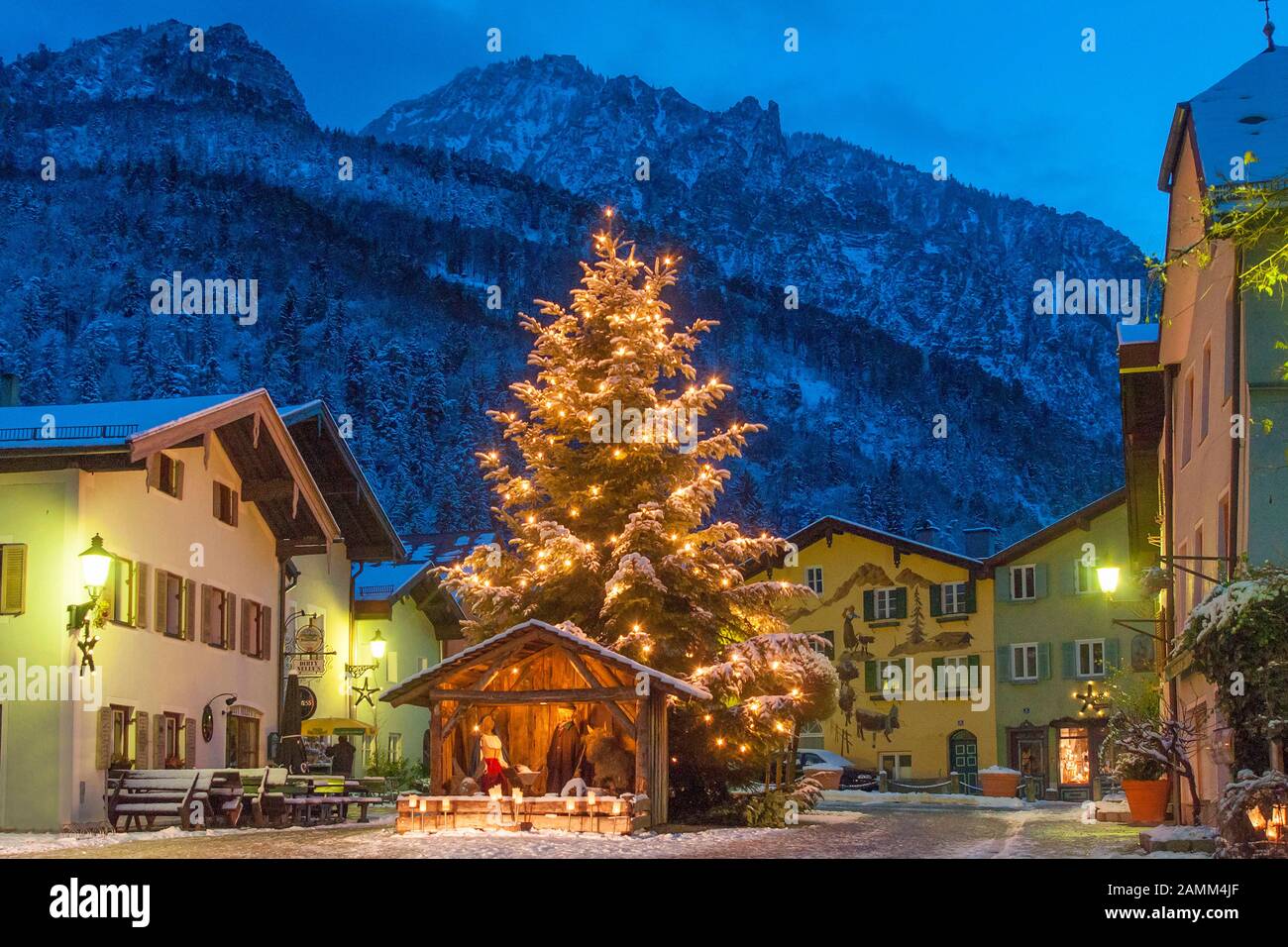 Meraviglioso presepe di natale con figure di fieno a grandezza naturale sulla neve invernale Florianiplatz a Bad Reichenhall con la sedia sermone sullo sfondo all'ora blu, uno dei quartieri più antichi di Bad Reichenhall in Berchtesgadener Land, Baviera, alta Baviera, Germania [traduzione automatizzata] Foto Stock