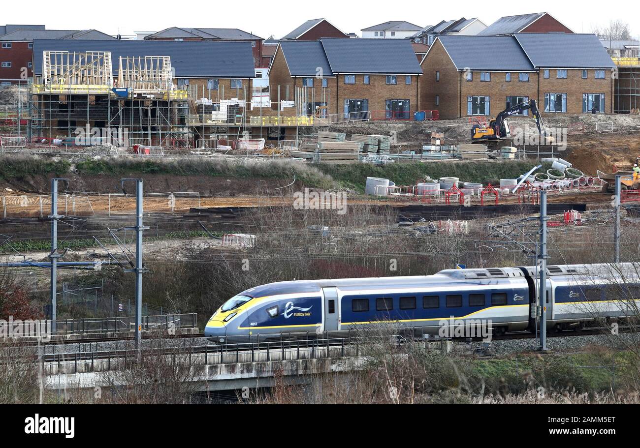 Un treno ad alta velocità sud-orientale passa nuove case costruite sullo sviluppo di Springhead in Ebbsfleet, Kent. Foto PA. Data Immagine: Lunedì 13 Gennaio 2020. Il credito fotografico dovrebbe leggere: Gareth Fuller/PA Wire Foto Stock