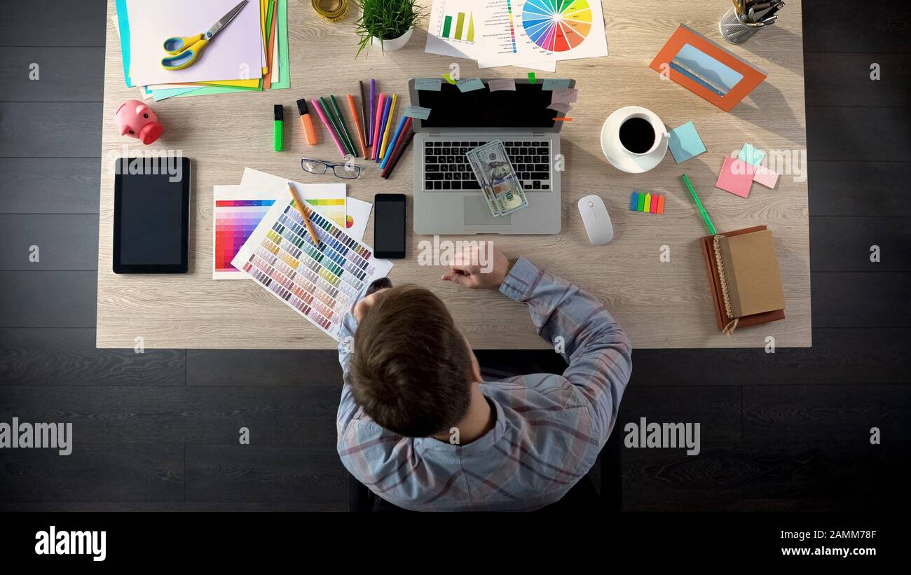 Povero editore d'arte contando poche banconote in dollari, sconvolto con piccola tassa per il progetto Foto Stock