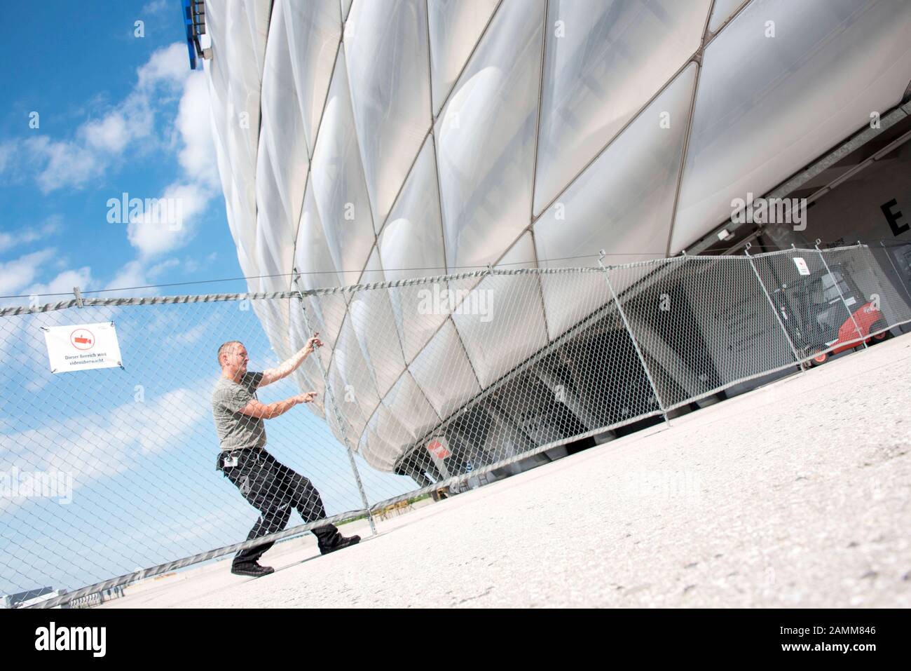 Sistema di recinzione mobile 'SecuFence' nella Allianz Arena di Monaco. Le scatole, in cui si trova la recinzione per l'estrazione, vengono spostate dal carrello elevatore a forche e impostate entro 10 minuti. L'immagine mostra un membro del team di custode che costruisce la recinzione metallica. [traduzione automatizzata] Foto Stock