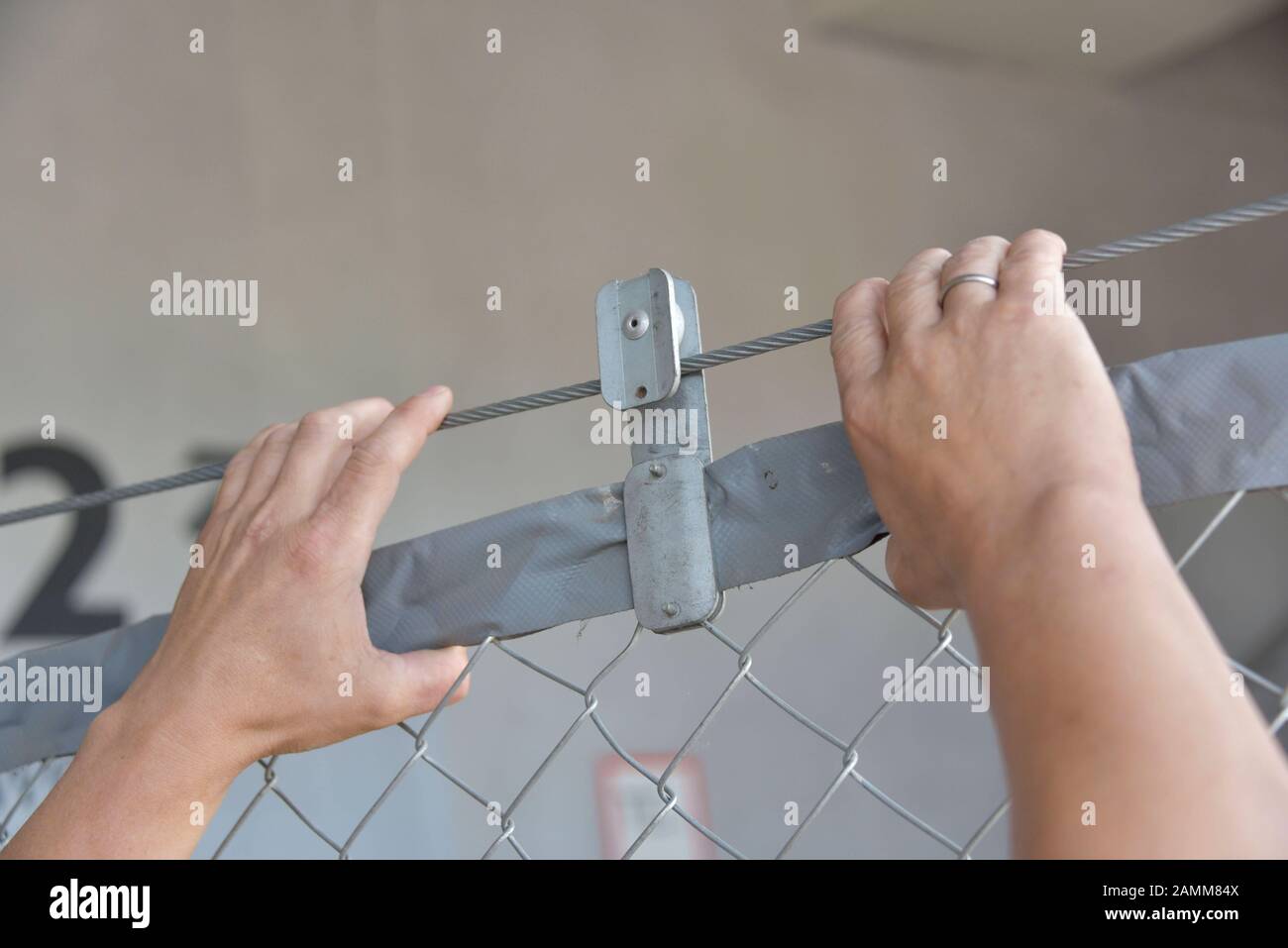 Sistema di recinzione mobile 'SecuFence' nella Allianz Arena di Monaco. Le scatole, in cui si trova la recinzione per l'estrazione, vengono spostate dal carrello elevatore a forche e impostate entro 10 minuti. L'immagine mostra un membro del team di custode che costruisce la recinzione metallica. [traduzione automatizzata] Foto Stock