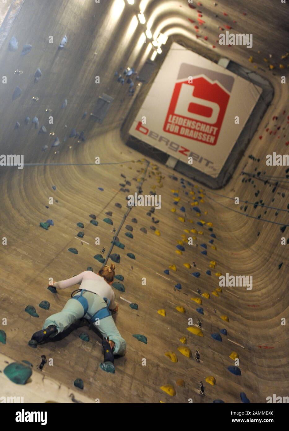 Donna che sale nella sala di arrampicata 'Porta Dei Cieli' sulla vecchia zona Pfanni a Ostbahnhof. [traduzione automatizzata] Foto Stock