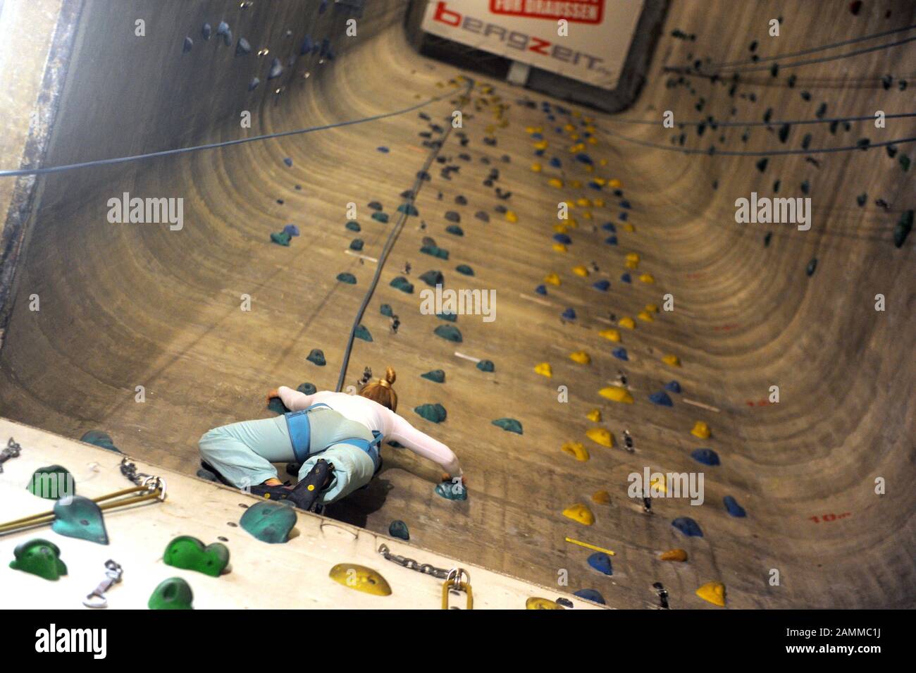 Donna che sale nella sala di arrampicata 'Porta Dei Cieli' sulla vecchia zona Pfanni a Ostbahnhof. [traduzione automatizzata] Foto Stock