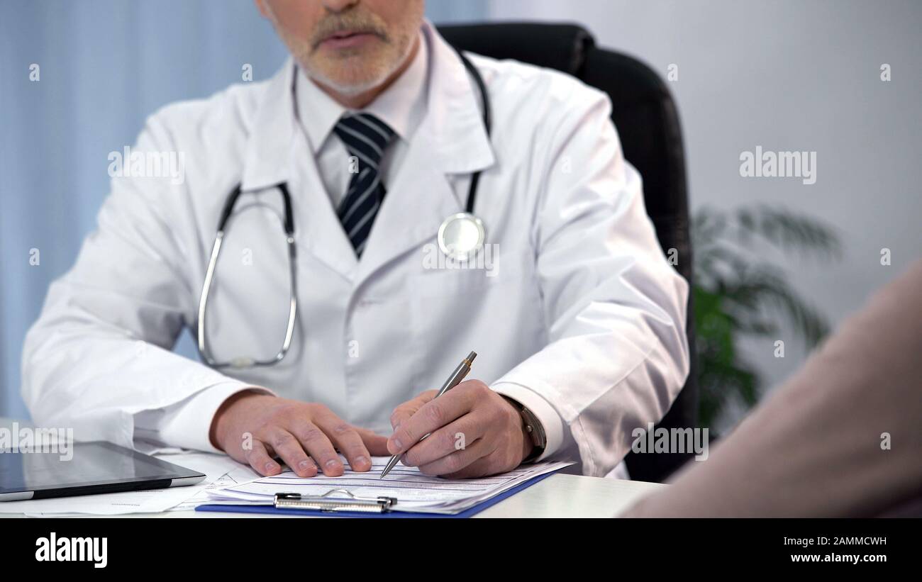 Terapista maschile compilazione modulo di registrazione e consulenza paziente, appuntamento Foto Stock
