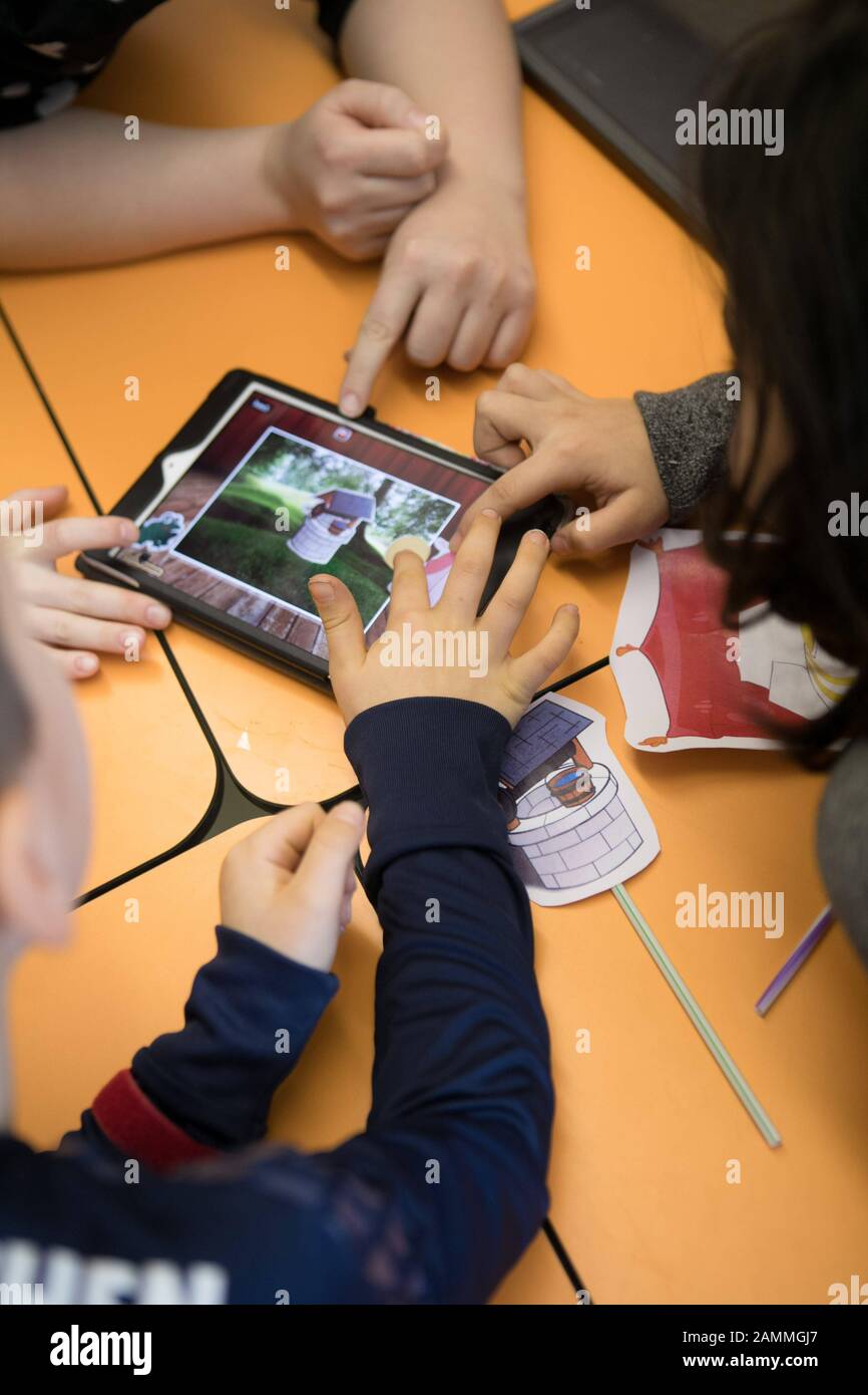 L'educazione digitale alla scuola elementare di Gänselieselstraße 33, esemplare nell'educazione dei media, è quindi una delle scuole di rete del progetto "Digital School 2020" in Baviera. Nella foto, gli studenti programmano e riemanano la fiaba del Re Frog su un tablet. [traduzione automatizzata] Foto Stock