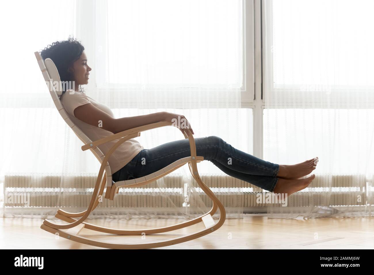 Rilassata donna africana che riposa su sedia dondolo in legno Foto stock -  Alamy