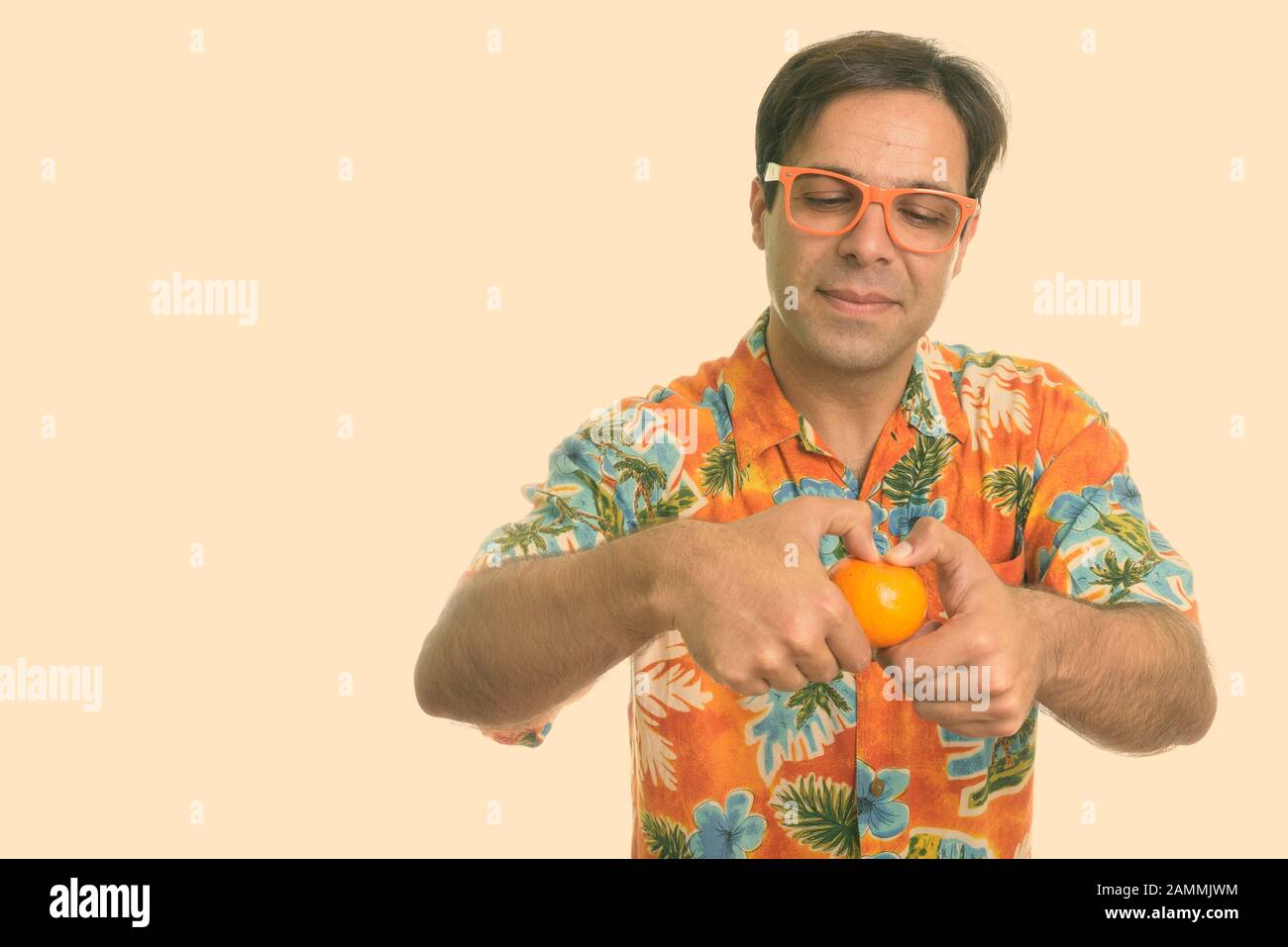 Monolocale di giovane turista persiano che apre arancione mentre indossa occhiali Foto Stock