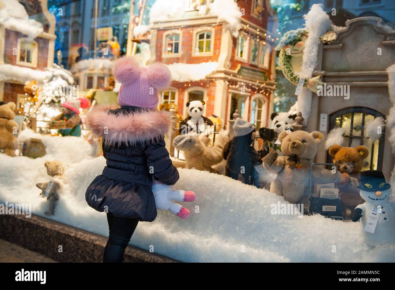 Una ragazza guarda le decorazioni natalizie nella vetrina della Galeria Kaufhof a Marienplatz. [traduzione automatizzata] Foto Stock