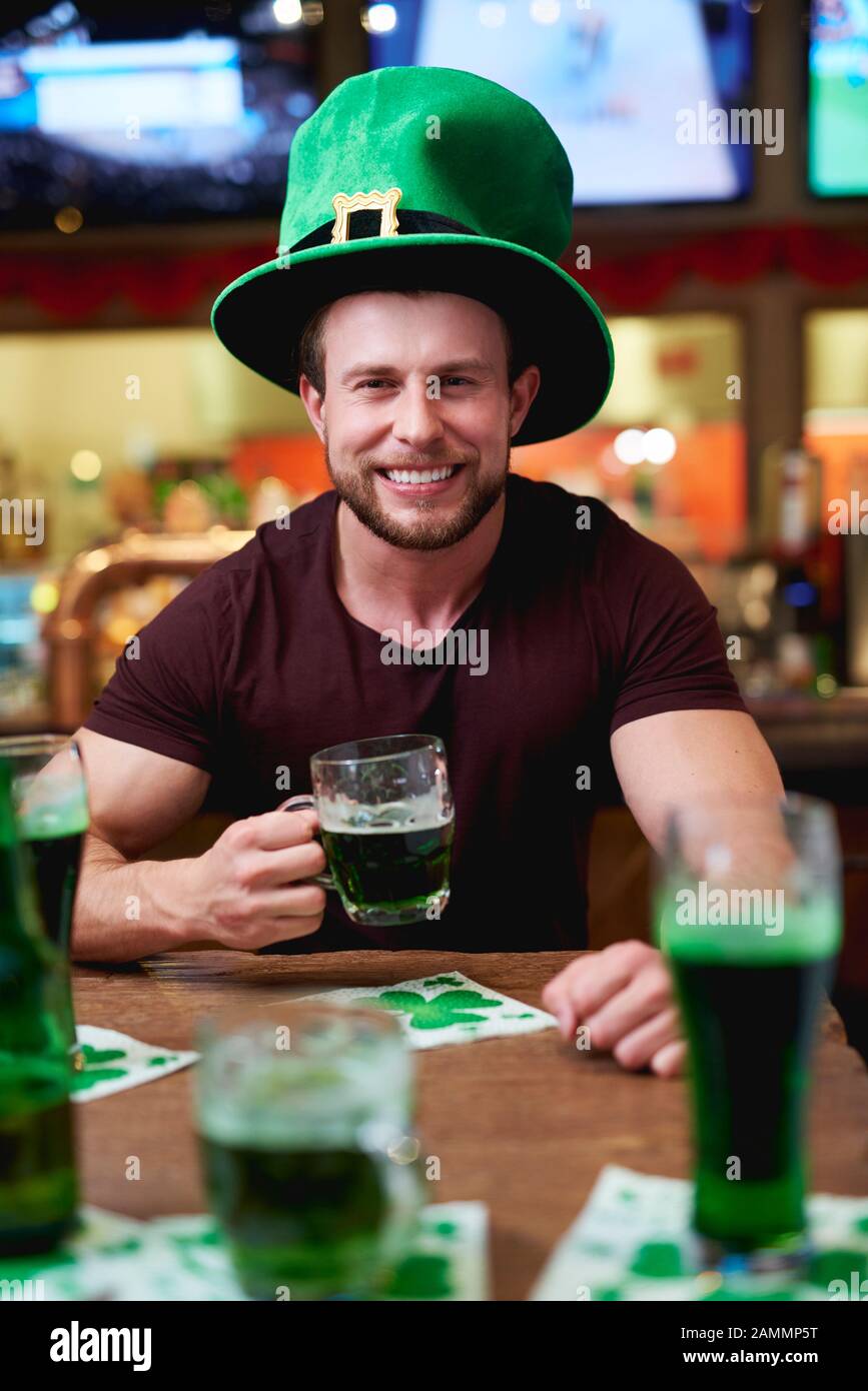 Uomo con cappello e birra di leprechaun che celebra il giorno di San Patrizio Foto Stock