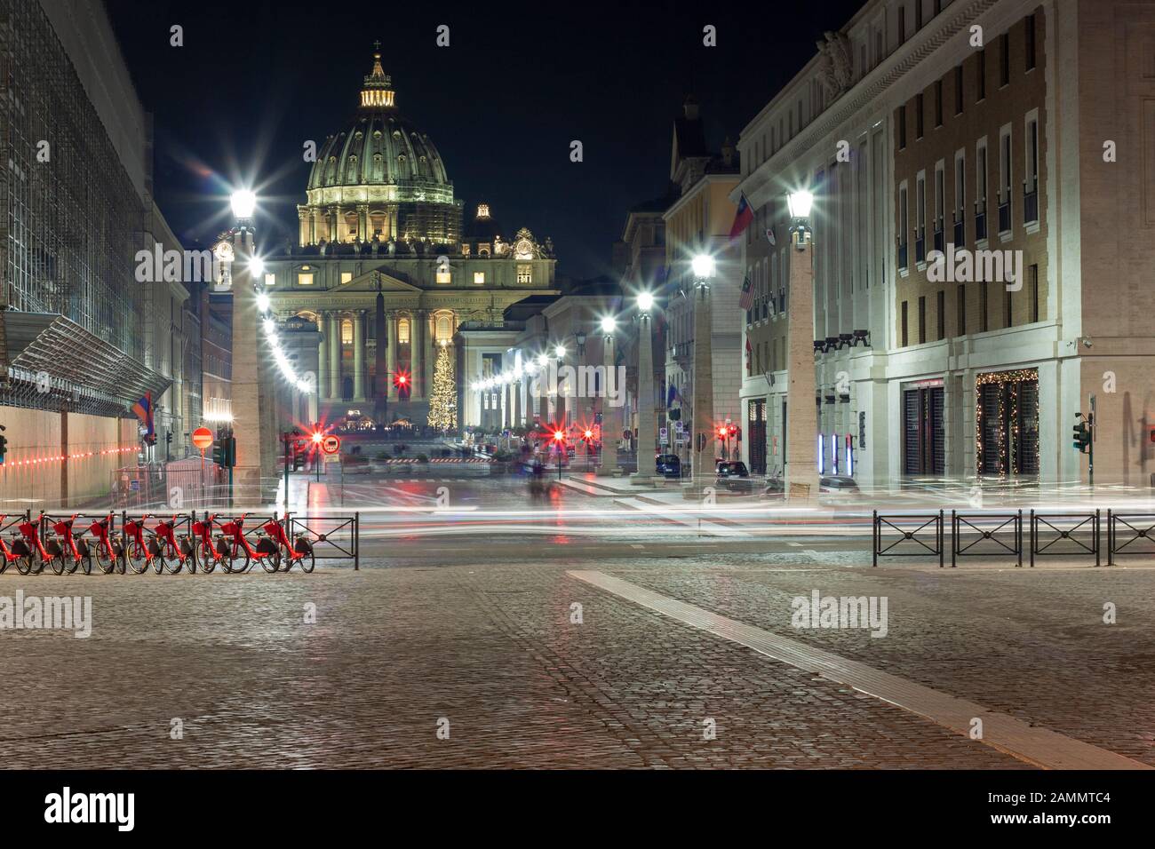 Roma. L'Italia. La basilica di san Pietro da Via della Conciliazione di notte con in Natale con il traffico lightrails Foto Stock