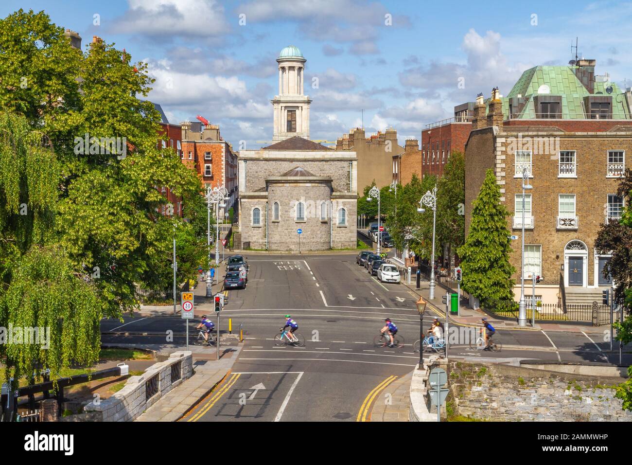 Ciclisti in bicicletta a Dublino usando la pista ciclabile. Vita di viaggio ecologico e verde. Pepper Canister Church, Dublino, Irlanda, architettura georgiana Foto Stock