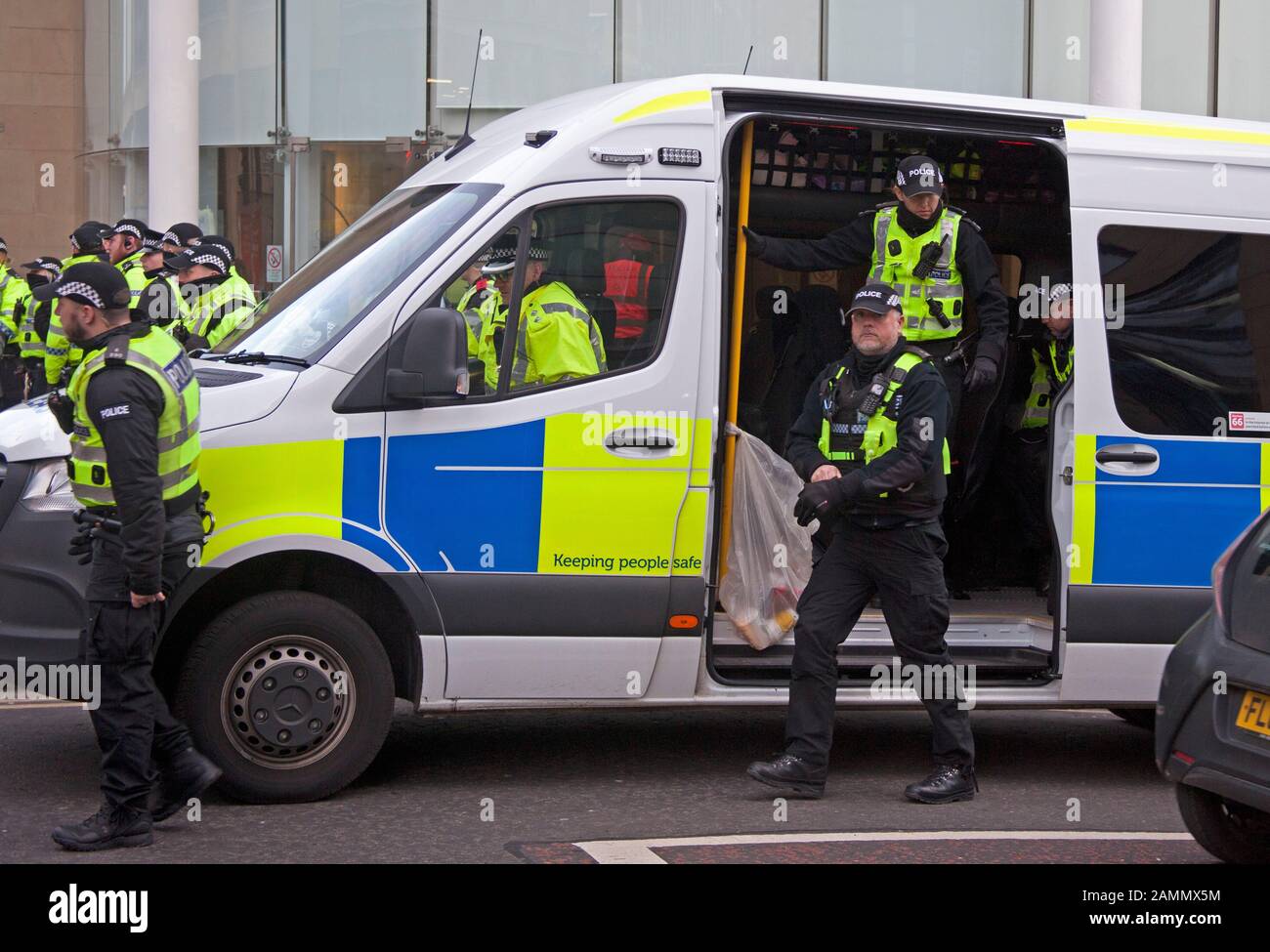 Gli ufficiali di polizia escono dal furgone per la dimostrazione del clima di estinzione Rebellion al di fuori di Baillie Gifford, Leith Street, Edimburgo, Scozia. 14 Gennaio 2020. Foto Stock